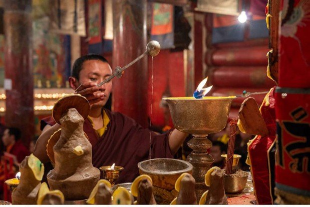 Figure 4.2.27: A monk uses a long-handled spoon [Tibetan ritual objects]